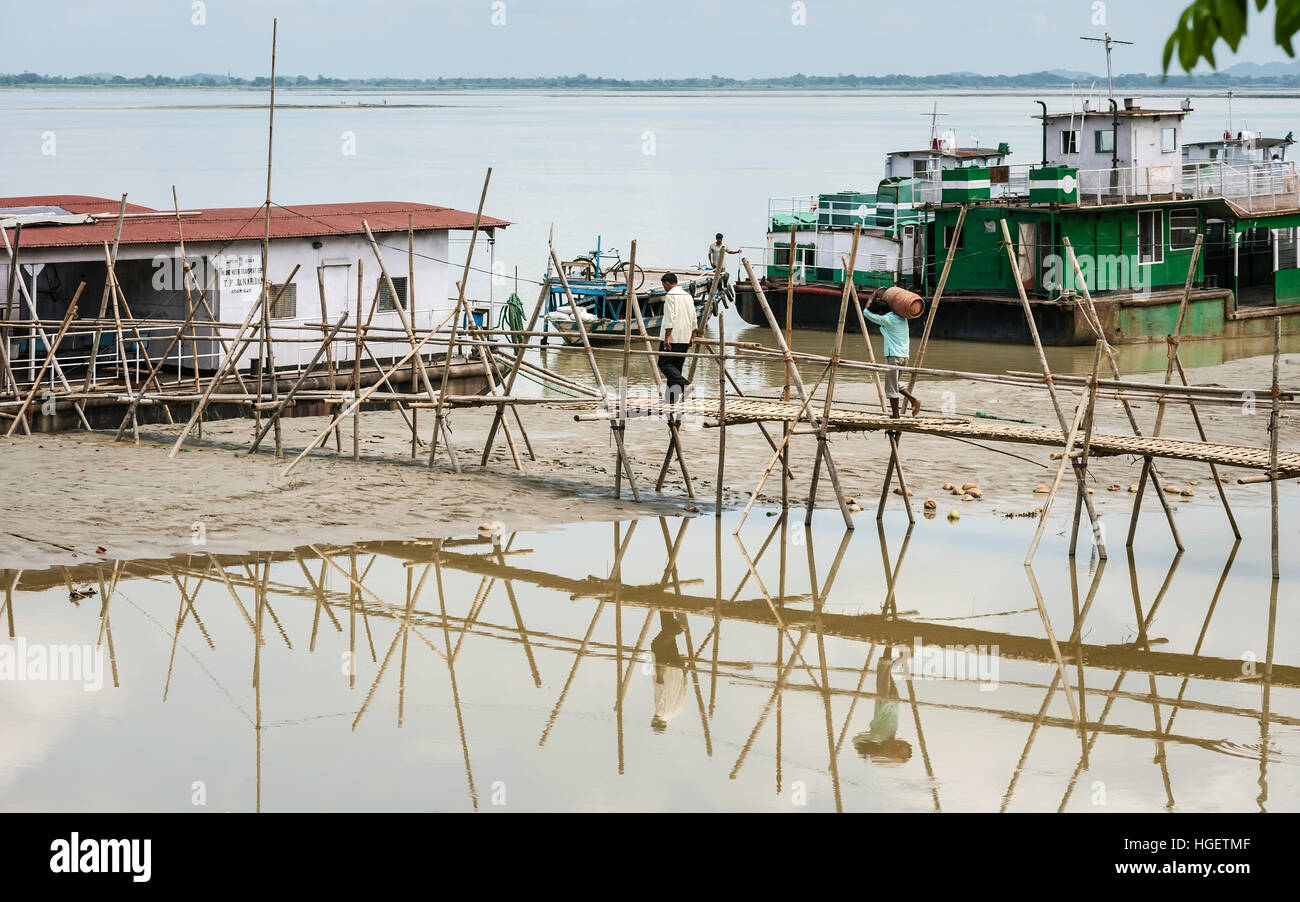 Les eaux de crue du Brahmapoutre reculer pour révéler bambou temporaire causeway entre rivière et de barges, de l'Assam. Banque D'Images