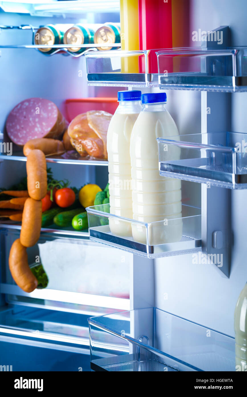 Ouvrir réfrigérateur rempli de nourriture. Se concentrer sur les bouteilles  de lait dans le réfrigérateur Photo Stock - Alamy
