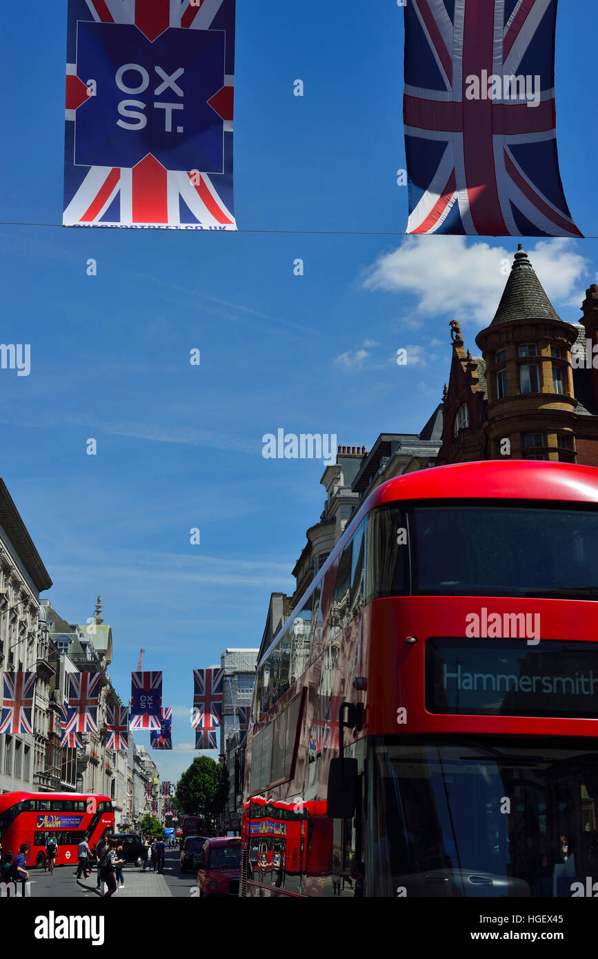 Oxford Street en été avec des drapeaux Union Jack et un bus rouge se déplaçant dans la rue. Banque D'Images