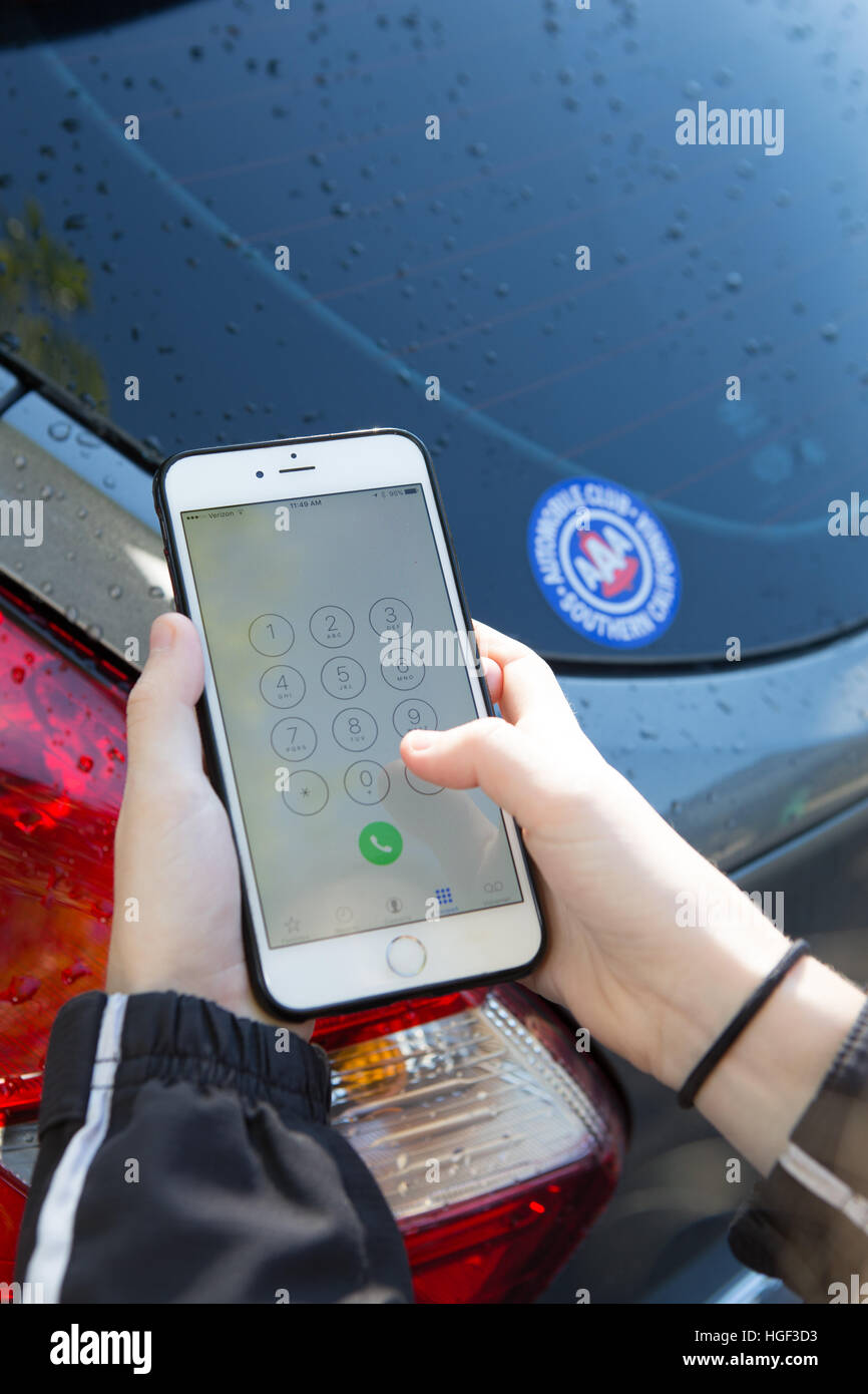 Jeune femme appelant à l'assistance routière sur son iphone6 plus. Automobile club AAA Membres du sud de la Californie sur l'autocollant de voiture Banque D'Images