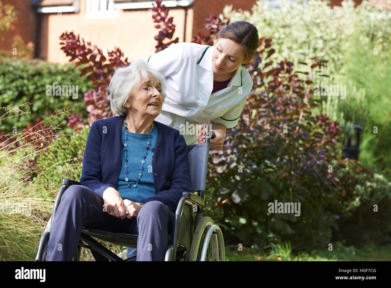 Carer poussant Senior Woman in Wheelchair Banque D'Images