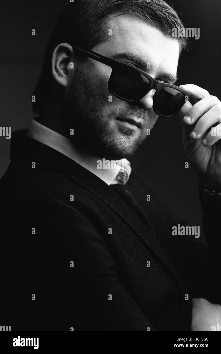 L'Homme à lunettes abaissé un peu dans la chambre noire Banque D'Images