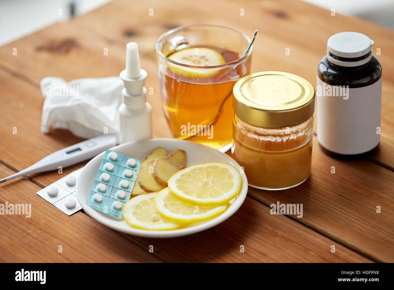 La drogue, thermomètre, le miel et une tasse de thé sur bois Banque D'Images