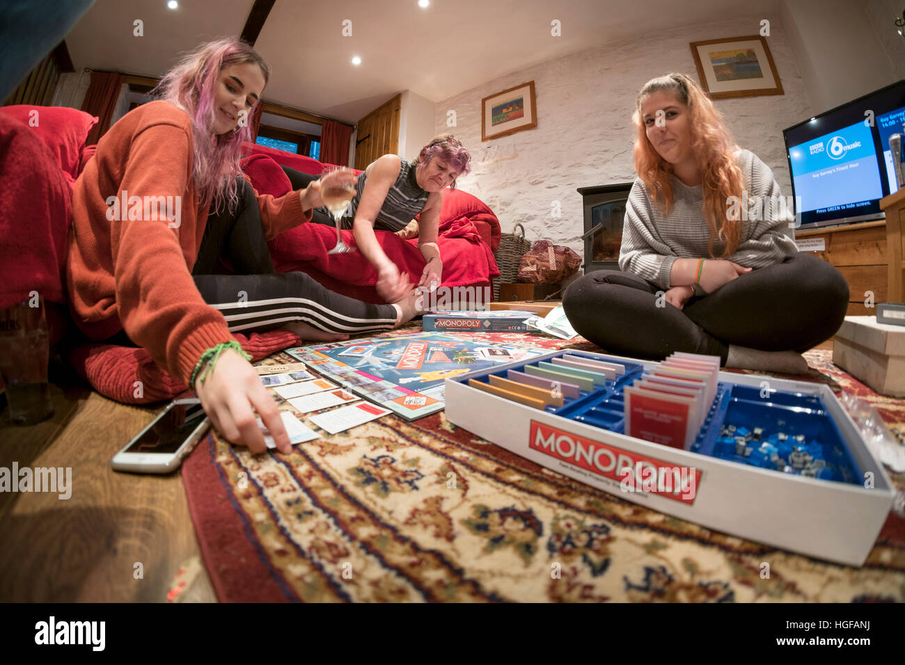 Divertissement Noël : Une mère et ses deux filles adultes jouant monopole sur le jour de Noël, soirée UK 2016 Banque D'Images