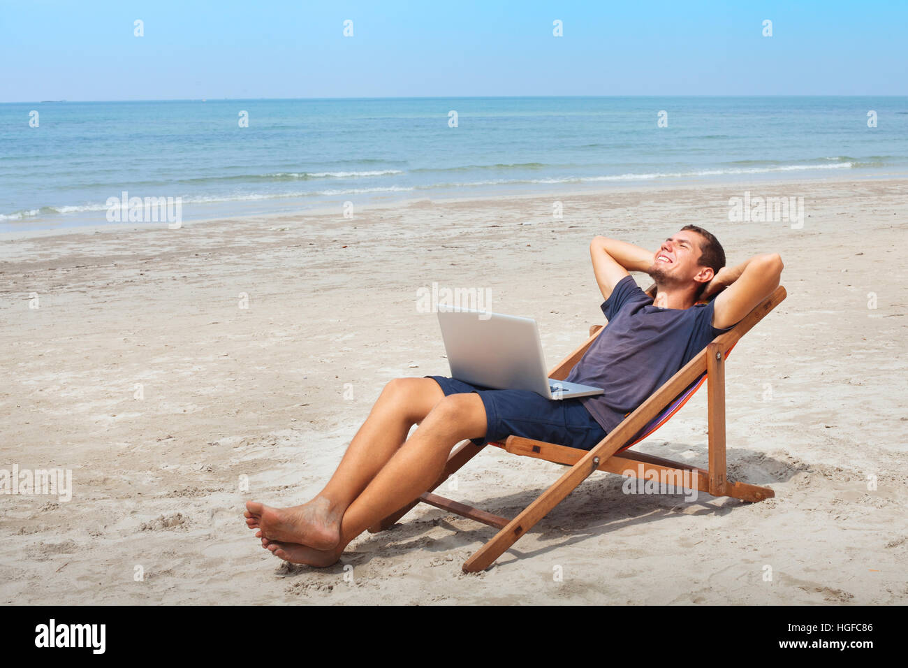 Indépendant avec un ordinateur portable sur la plage, les happy business man relaxing, travail freelance Banque D'Images