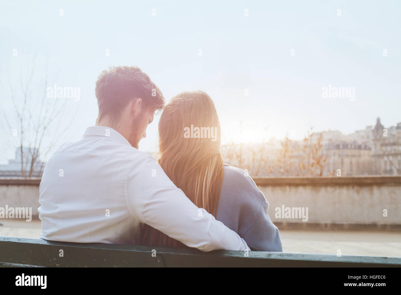 Dating ou premier amour, jeune couple assis ensemble sur le banc, vue par l'arrière Banque D'Images
