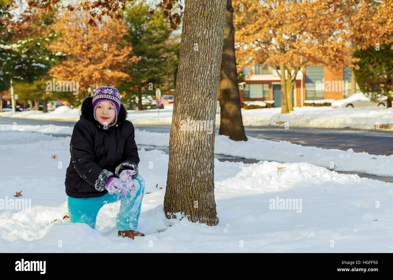 Cute girl en jouant avec un habit chaud la neige. Petit enfant jouer s'amuser en plein air building snowman dans la forêt. Banque D'Images