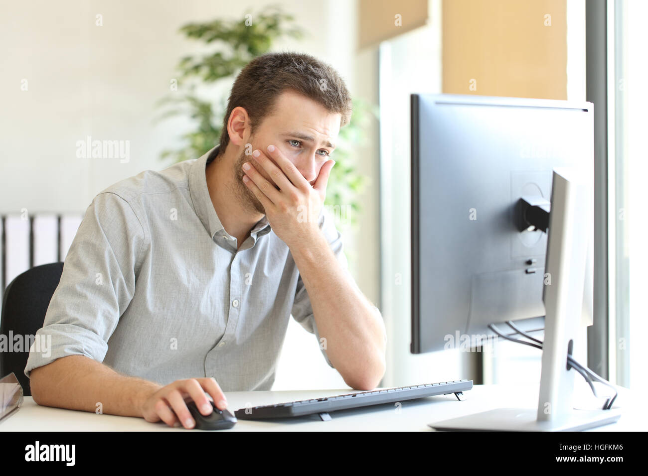 Businessman working inquiets d'essayer de résoudre des problèmes en ligne avec un ordinateur de bureau au bureau Banque D'Images
