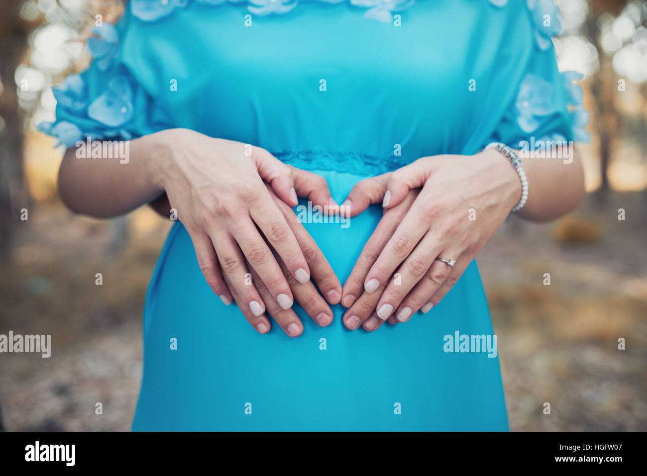 Pregnant couple mains tenant le ventre. Banque D'Images