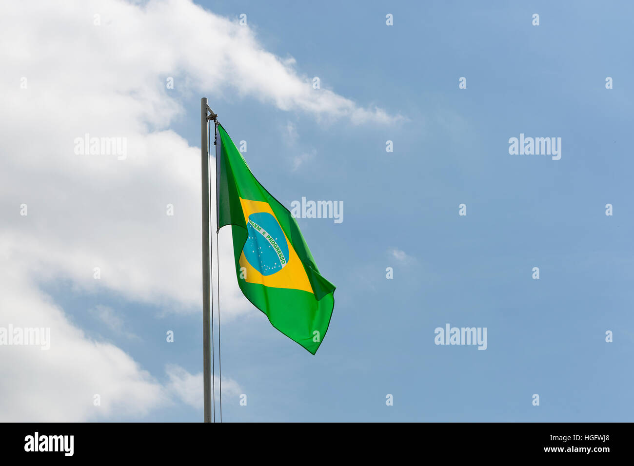 Drapeau national du Brésil sur un poteau en face de ciel bleu Banque D'Images