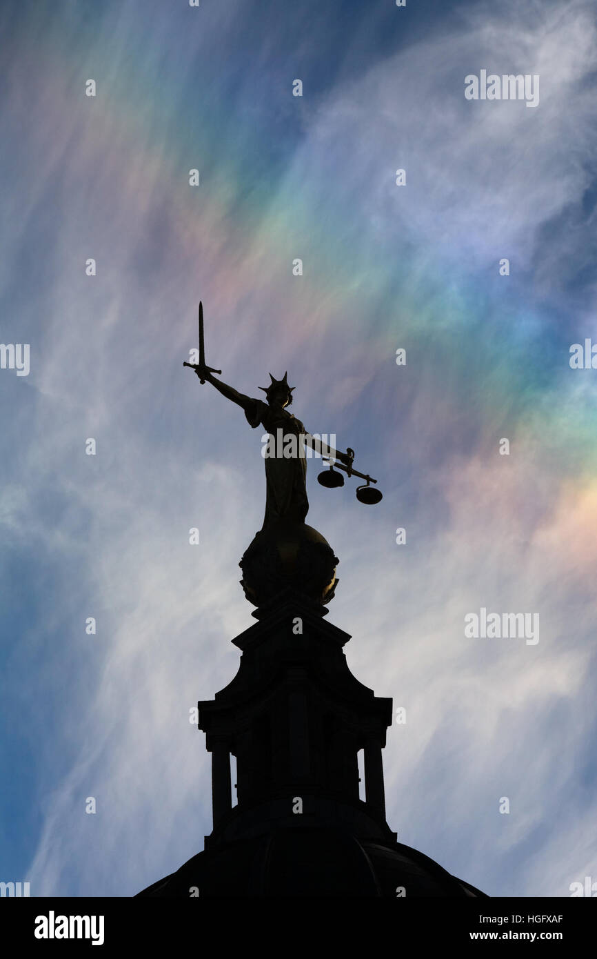 Dame Justice au sommet de l'Old Bailey à Londres, silhouetté contre un bleu ciel avec un léger arc-en-ciel. Banque D'Images