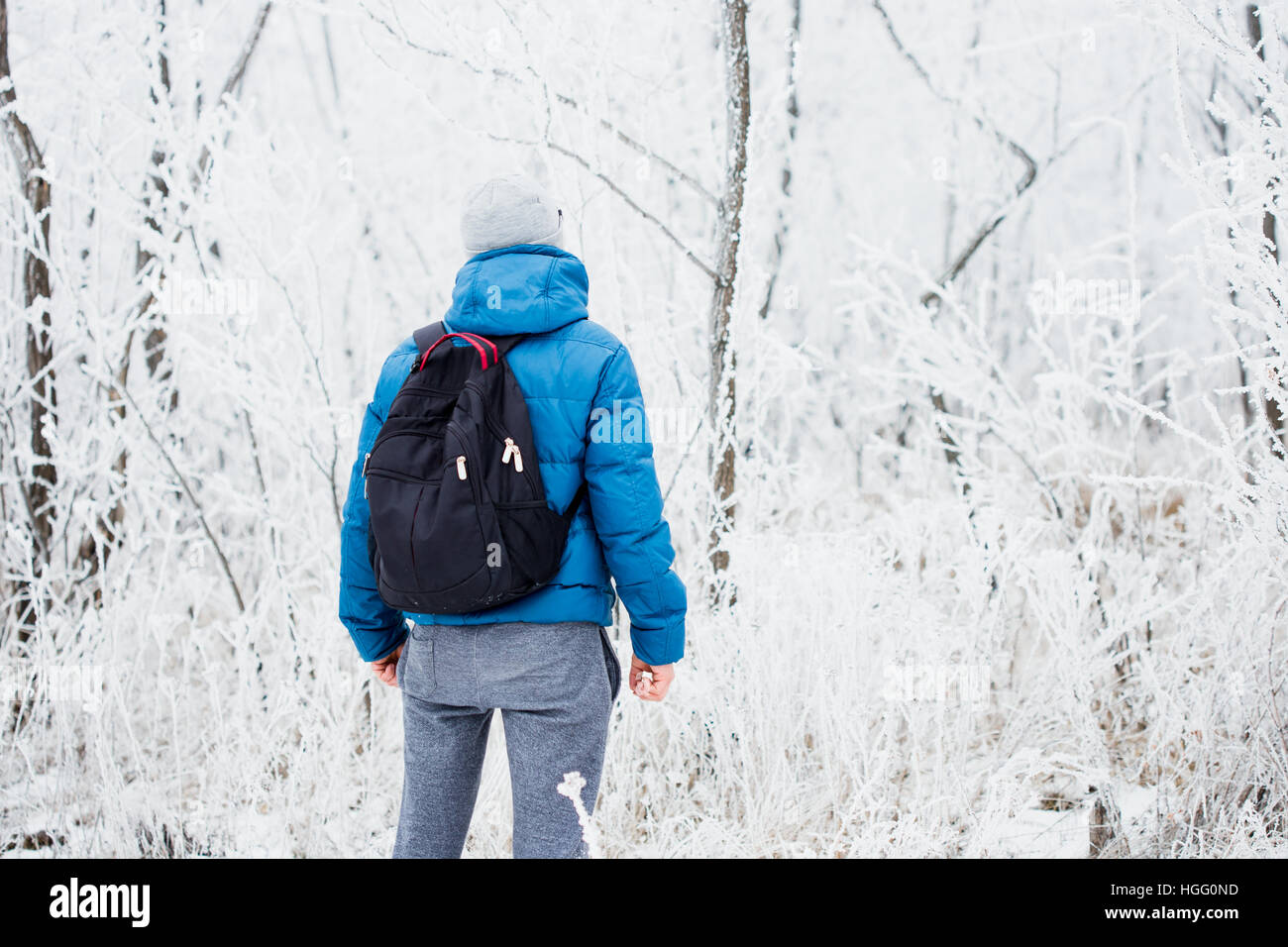Jeune homme tout seul dans l'hiver la forêt enneigée Banque D'Images