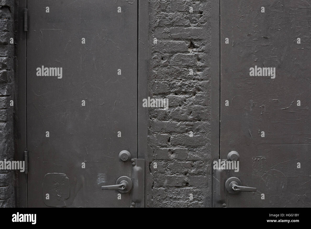 Vieilles portes en métal gris et mur de briques peint Banque D'Images