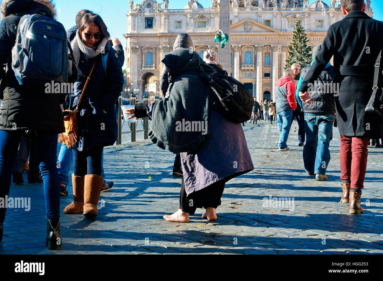 Mendiant non identifié mendiant parmi une foule de gens passant par la place Saint-Pierre. Vatican, Rome, Italie, Europe, Union européenne, UE. Banque D'Images