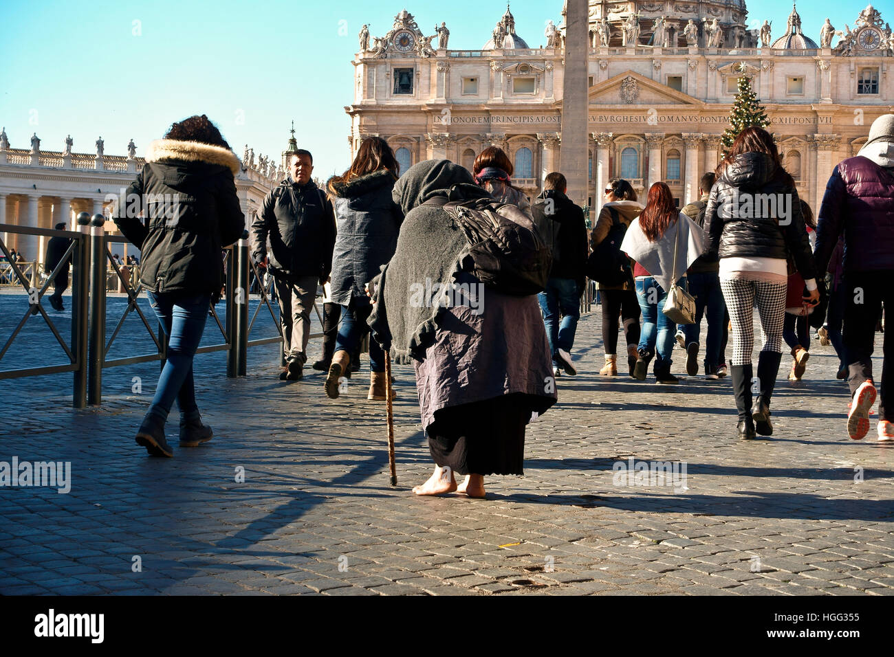 Mendiant non identifié mendiant parmi une foule de gens passant par la place Saint-Pierre. Vatican, Rome, Italie, Europe, Union européenne, UE. Banque D'Images