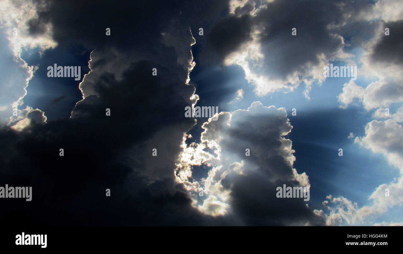 Grade de nuages avec soleil juste derrière la grande colonne sombre de nuages Banque D'Images