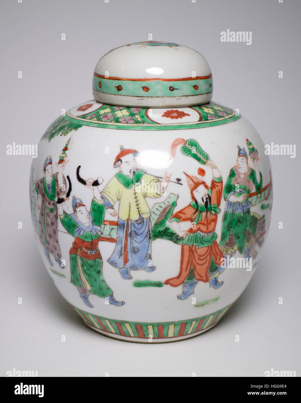 Vintage porcelaine chinoise Famille Verte pot et couvercle peint avec des chiffres dans une procession. Le pot et couvrir des mesures 20cm de haut et a un Chinois fou Banque D'Images