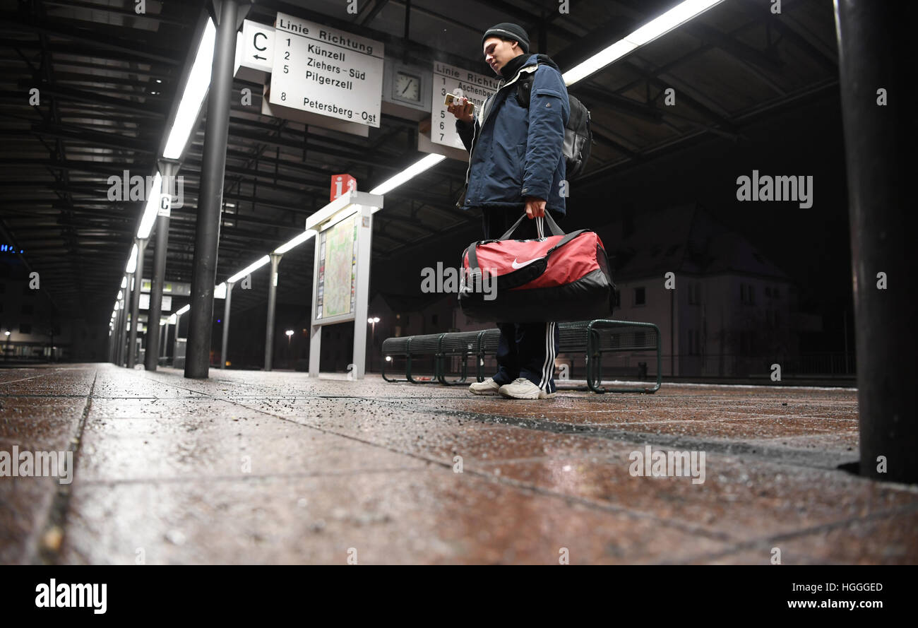 Fulda, Allemagne. Jan 9, 2017. Philipp étudiant Walde se penche sur son smartphone à la gare routière centrale (ZOB) à Fulda, Allemagne, le 9 janvier 2017. Le syndicat Verdi appelés conducteurs de bus dans plusieurs villes de Hesse pour une grève. Verdi et de l'Etat association des conducteurs d'autocars en Hesse (Lho) négocier un nouveau contrat tarifaire. Photo : Arne Dedert/dpa/Alamy Live News Banque D'Images