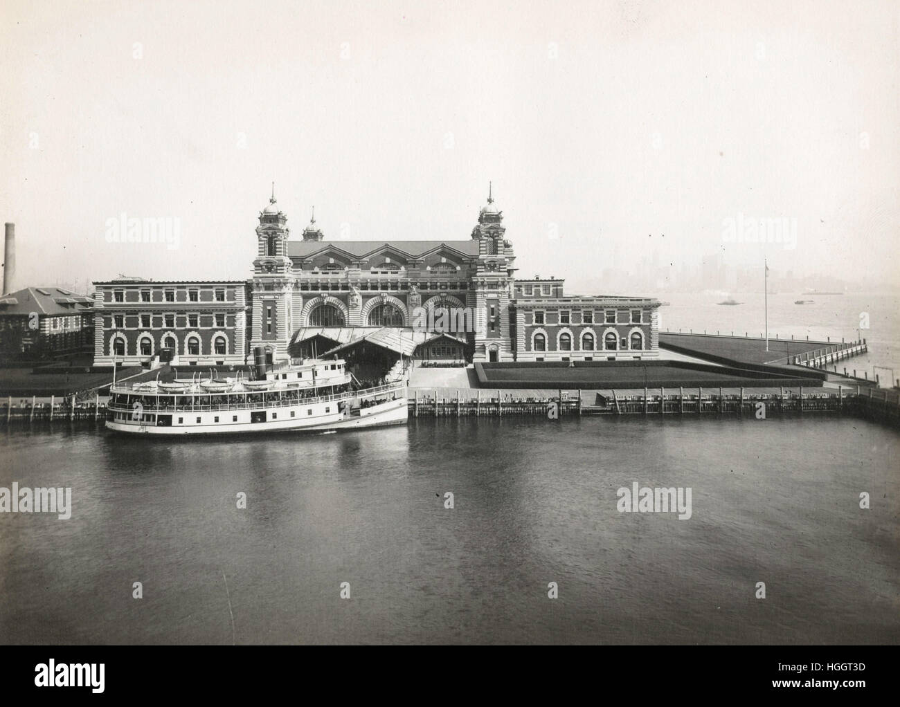 Une excellente vue de la façade avant de la station d'immigration ; un bateau est amarré en face de la station de l'Immigration d'Ellis Island - 1902-1913 - Photo : Edwin Levick Banque D'Images