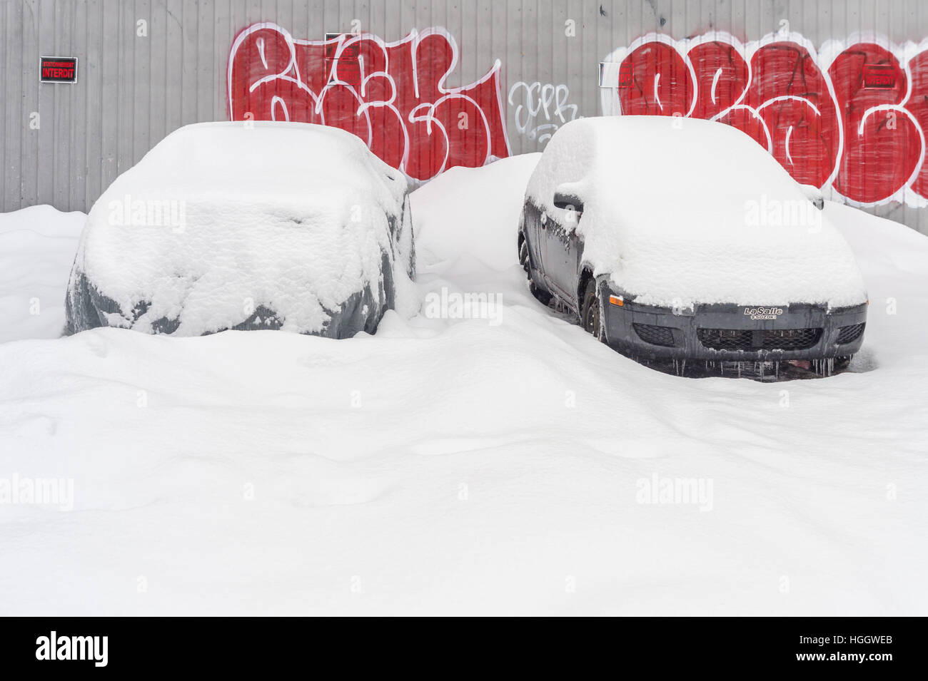 Montréal, CA - 4 janvier 2017 : deux voitures en stationnement couvert de neige avec des tags sur l'arrière-plan Banque D'Images