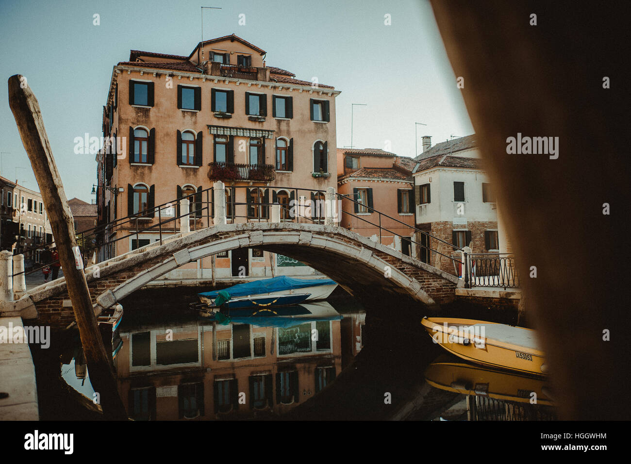 Un pont, quelques maisons et quelques bateaux à Venise. Ils sont tous reflétant dans l'eau du canal. Banque D'Images