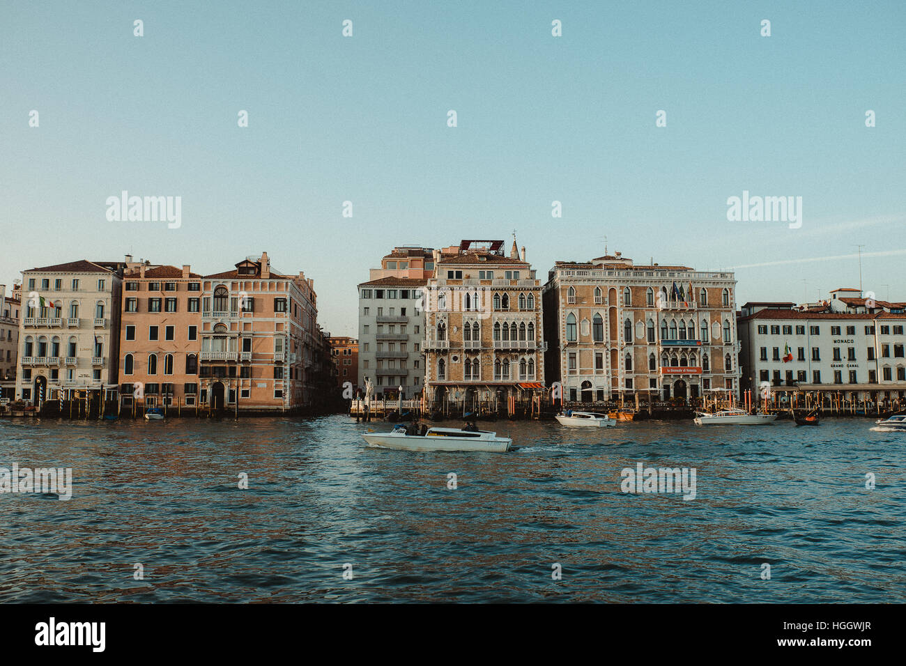Vue sur façades à Venise, Italie. Un grand canal avec quelques bateaux est au premier plan. Banque D'Images