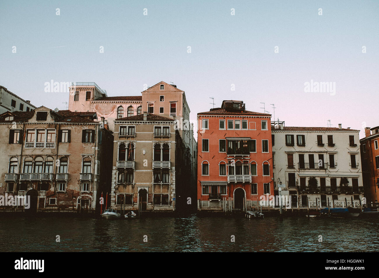 Un bateau avec un couvercle rouge dans un canal à Venise, Italie. Banque D'Images
