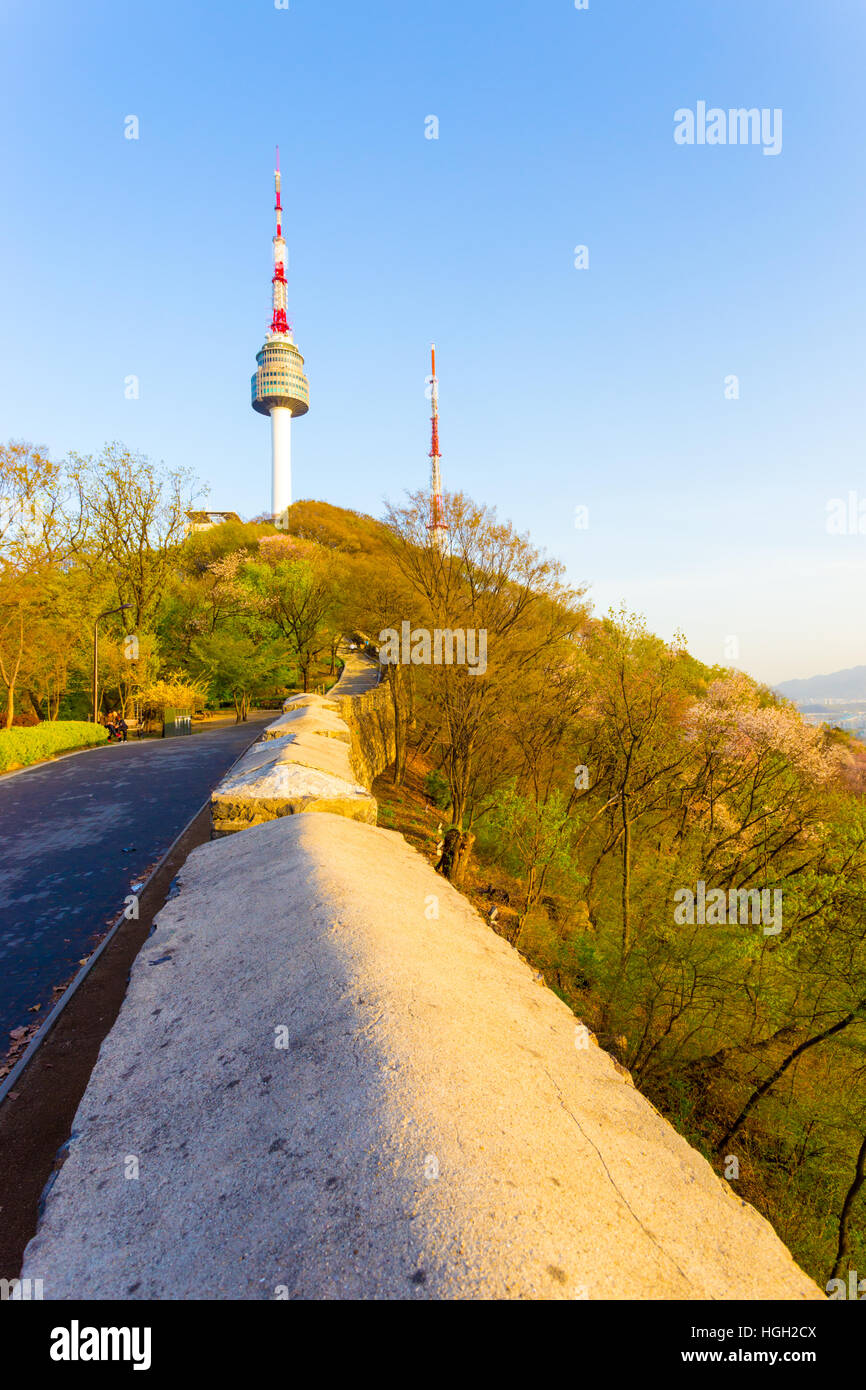 Paysage de colline N Séoul tour au sommet de la montagne Namsan vu au-dessus de vieux mur de ville et des piétons sur sentier, ciel bleu clair jour Banque D'Images