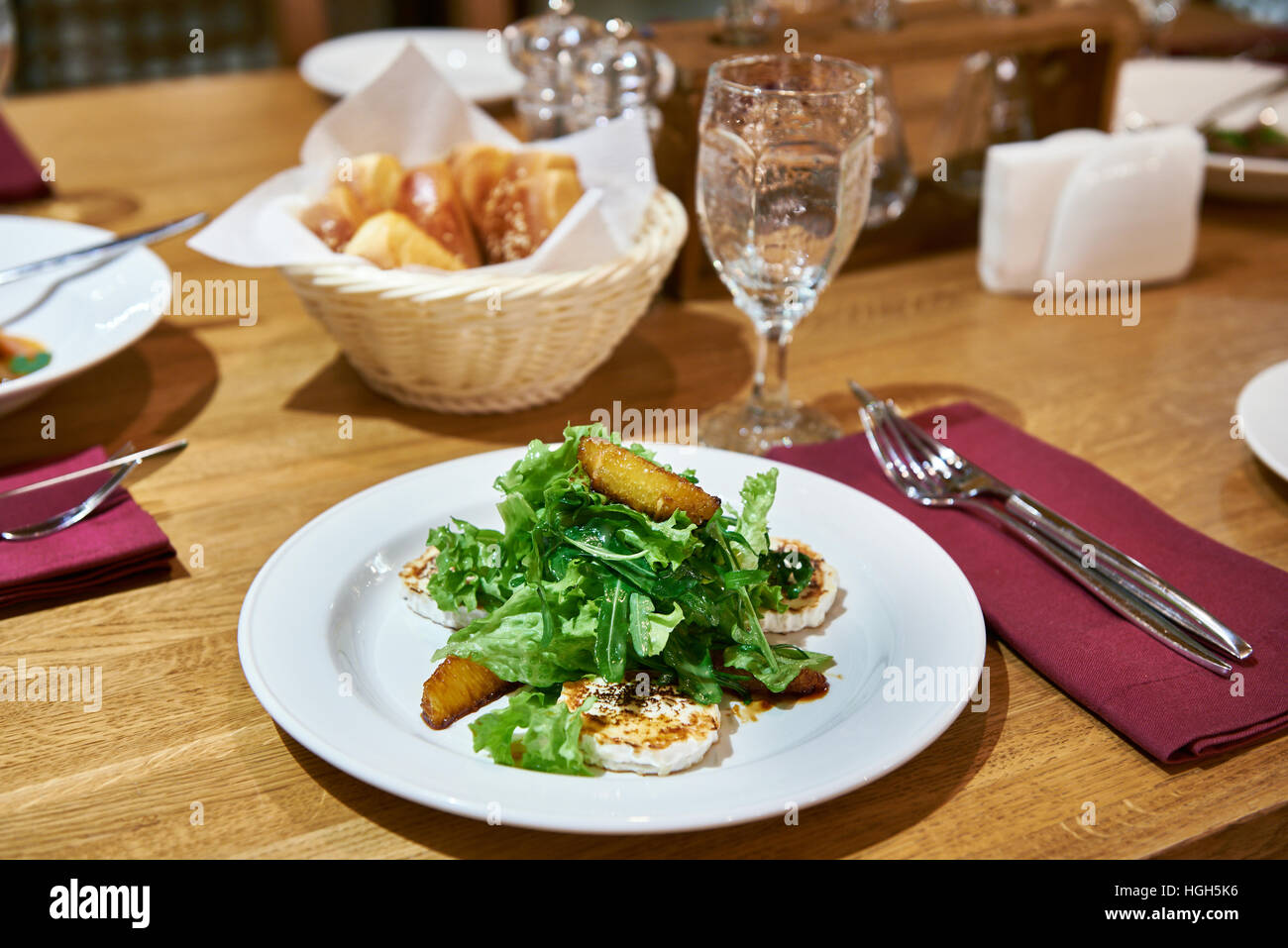 Avec la salade de roquette avec fromage frit et les tranches d'orange sur une table à manger Banque D'Images
