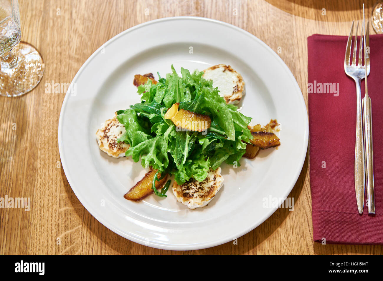 Avec la salade de roquette avec fromage frit et les tranches d'orange sur une table à manger Banque D'Images