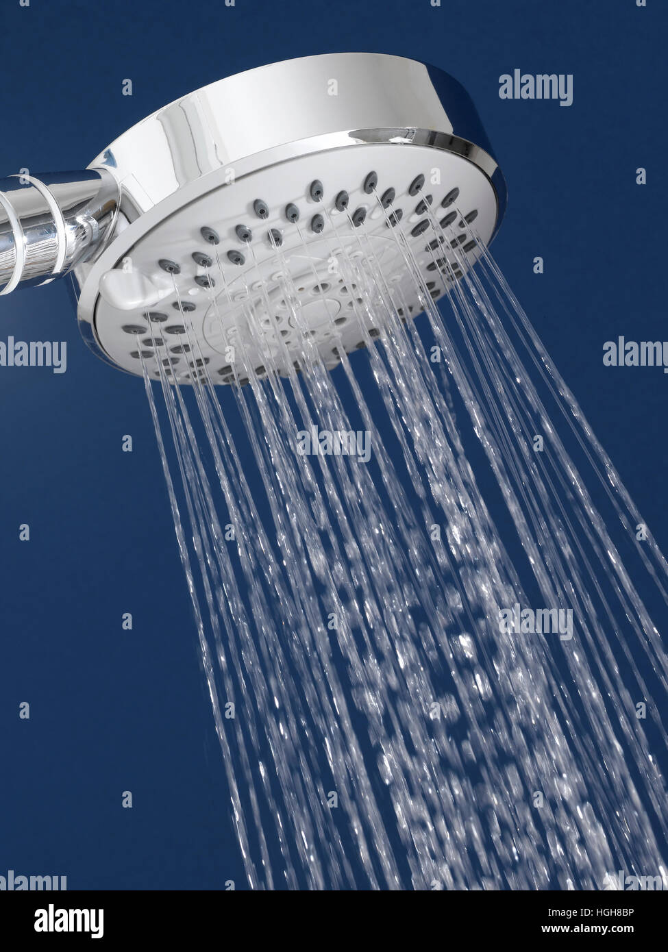 Pomme de douche Chrome avec de l'eau qui coule dans une salle de bains  bleue Photo Stock - Alamy