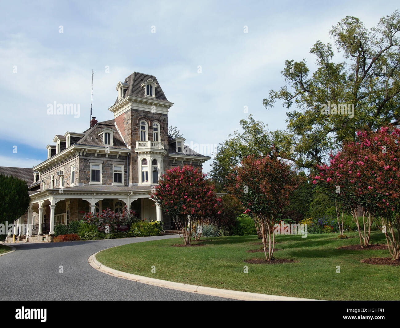 L'hôtel particulier, à Cylburn Cylburn Arboretum, à Baltimore, Maryland, avec Crepe Myrtle les arbres et autres plantes à feuillage en fleurs sur une journée d'été. Banque D'Images