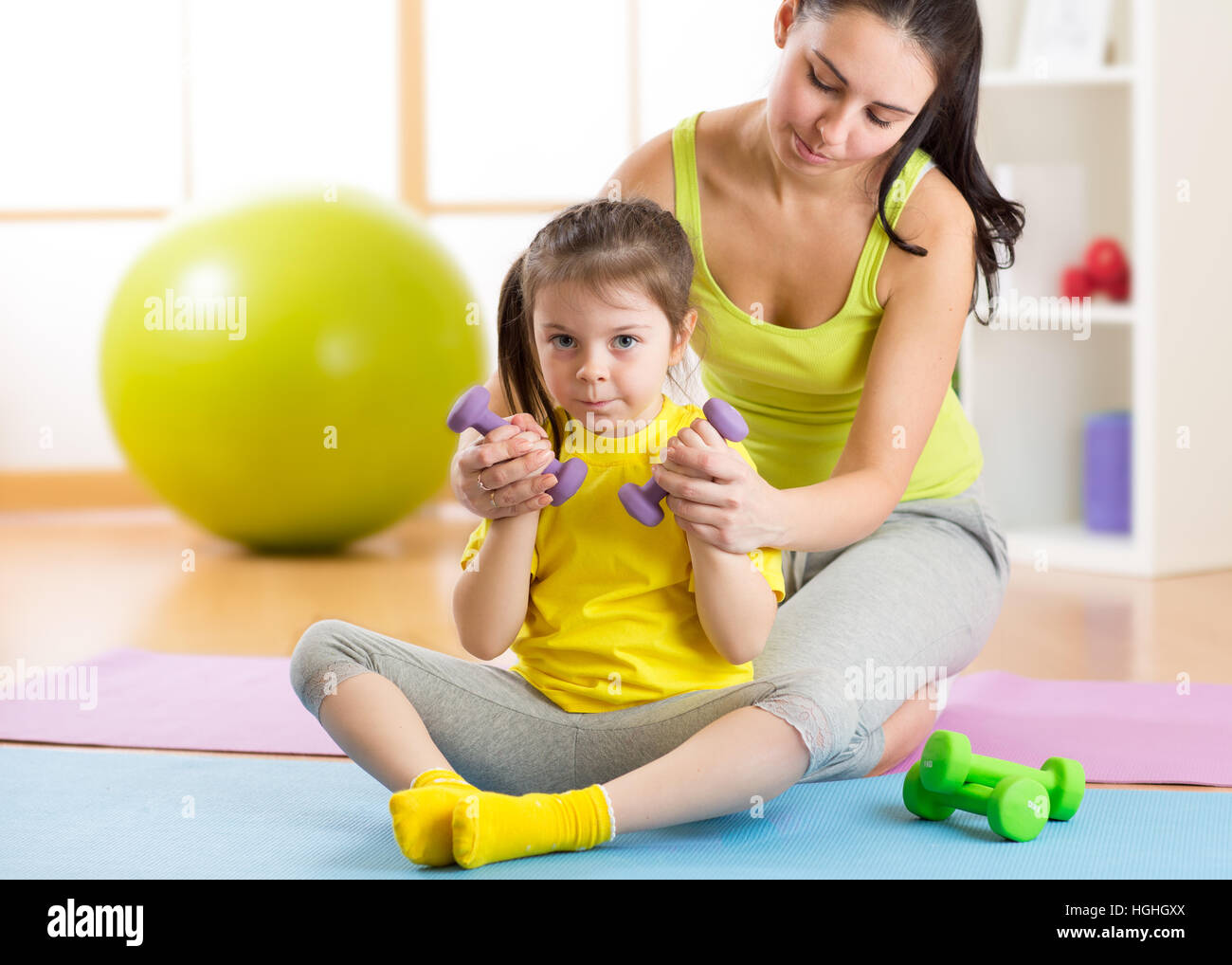 Jeune femme séduisante et son enfant fille l'entraînement avec haltères courtes Banque D'Images