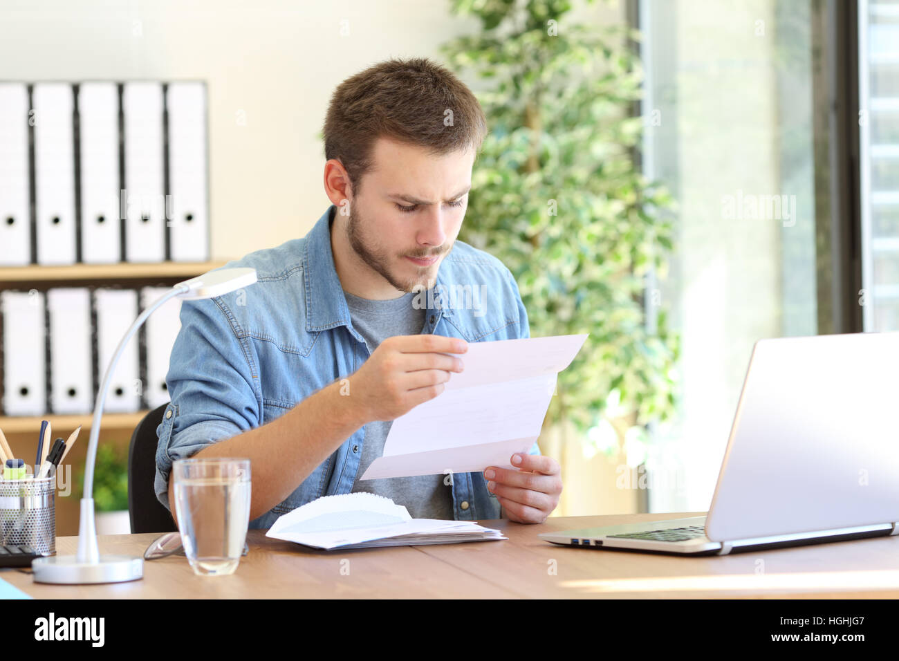 Entrepreneur sérieux et de lecture une lettre dans un bureau au travail Banque D'Images