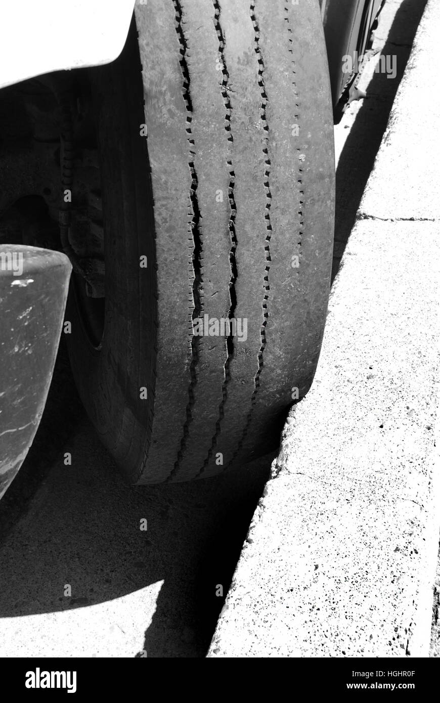 Voiture garée contre le trottoir ne se déplace pas avec du ciment contre des pneus Banque D'Images