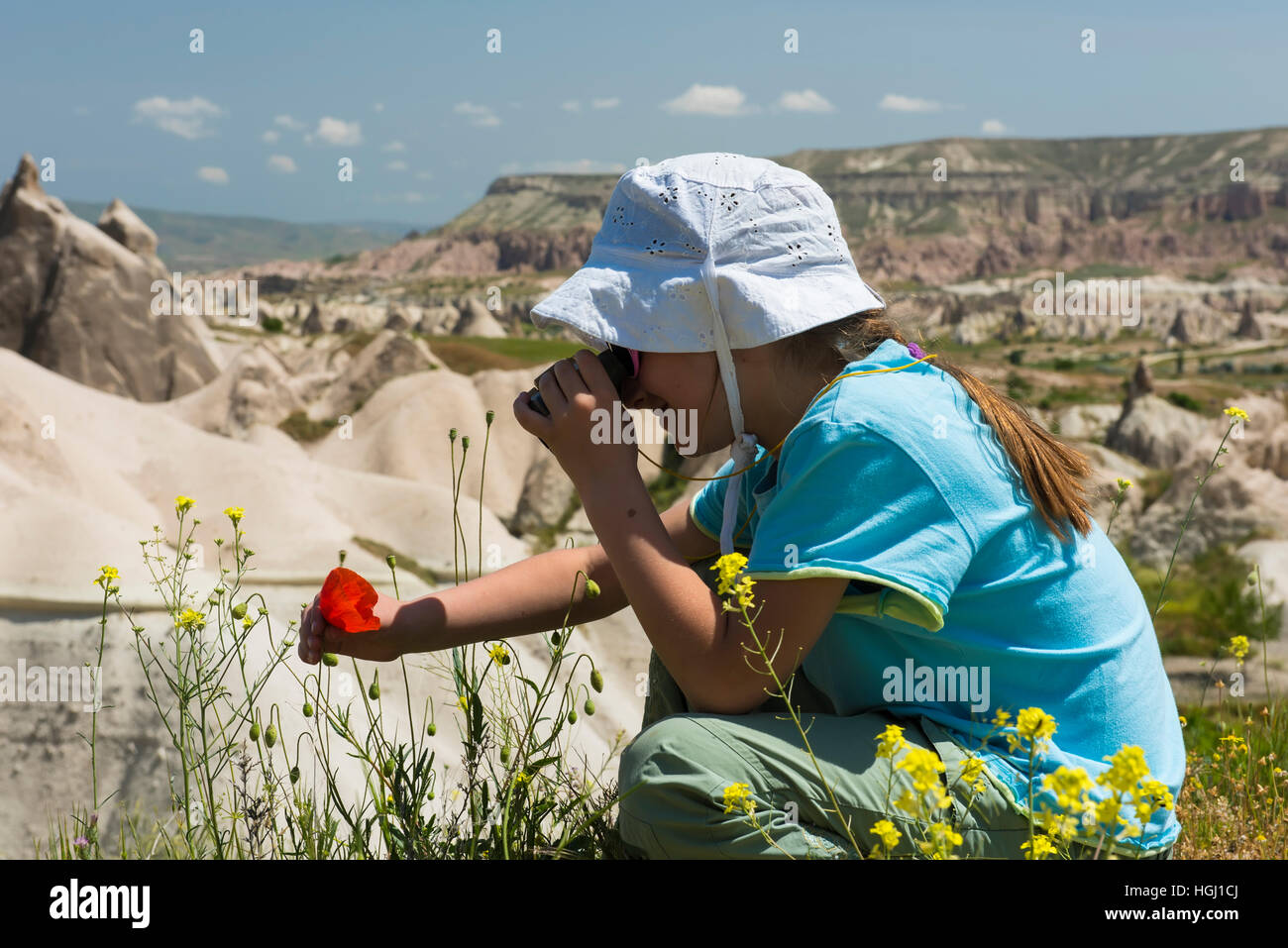 Petite fille avec des jumelles dans les montagnes Banque D'Images