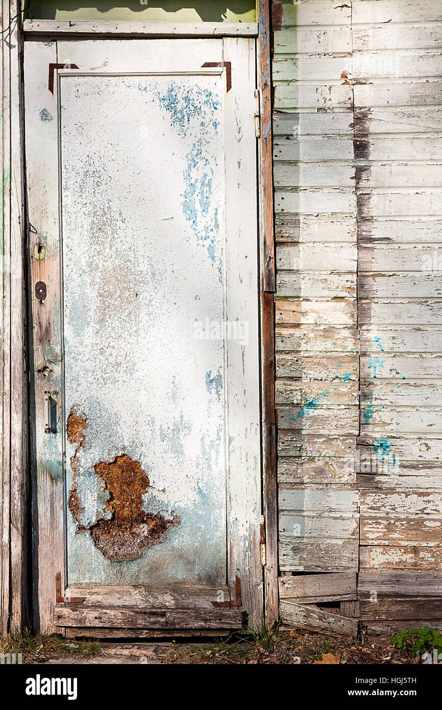 Vue rapprochée de la vieille porte en bois avec peinture la couleur est arrachée. Peinture écaillée sur porte de maison abandonnée comme texture de fond bois vintage. Banque D'Images