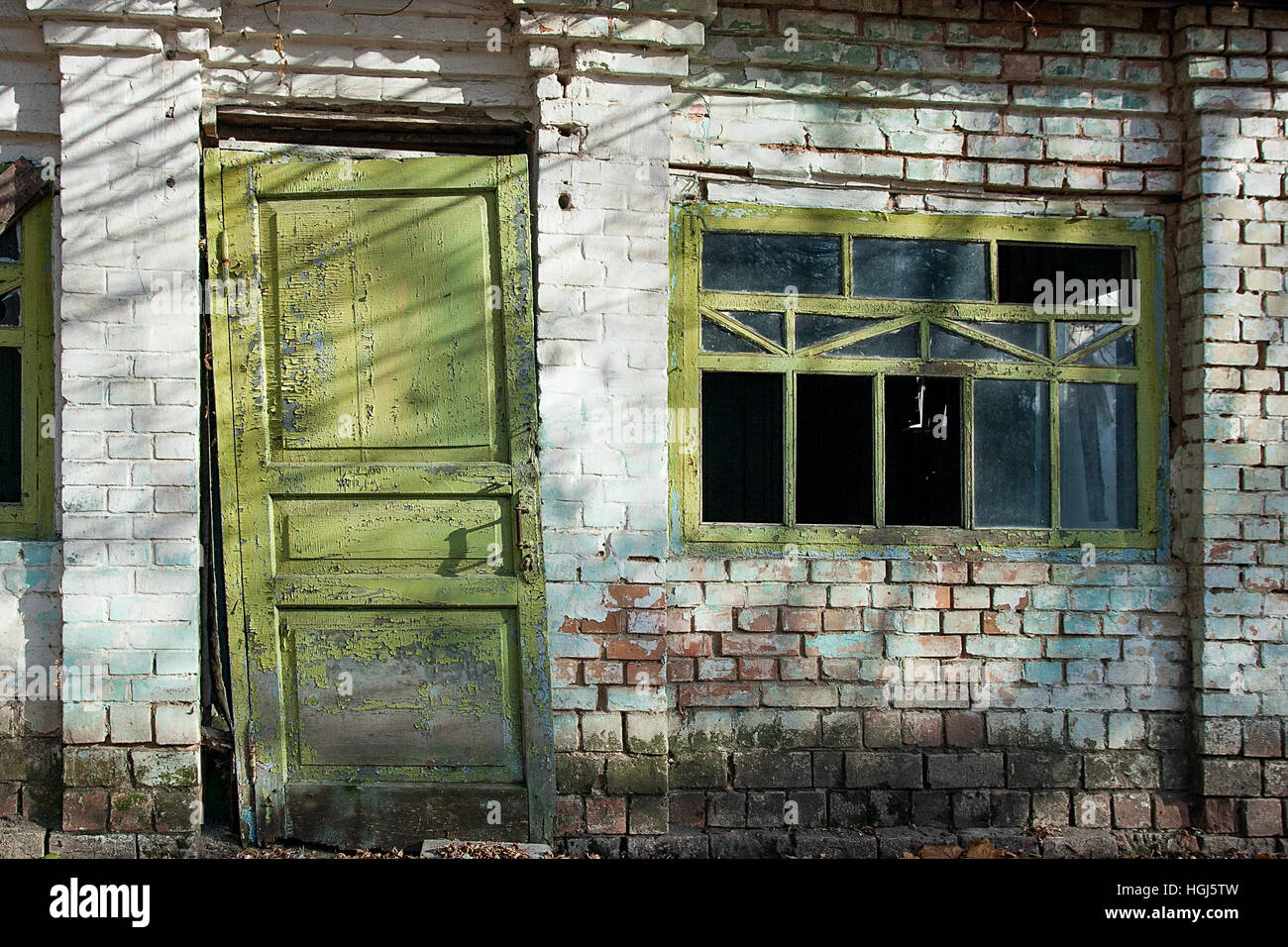 Vue rapprochée de l'ancienne en bois avec porte fenêtre cassée et couleur peinture écaillé. Peinture écaillée sur fenêtre cassée et porté porte de maison abandonnée Banque D'Images