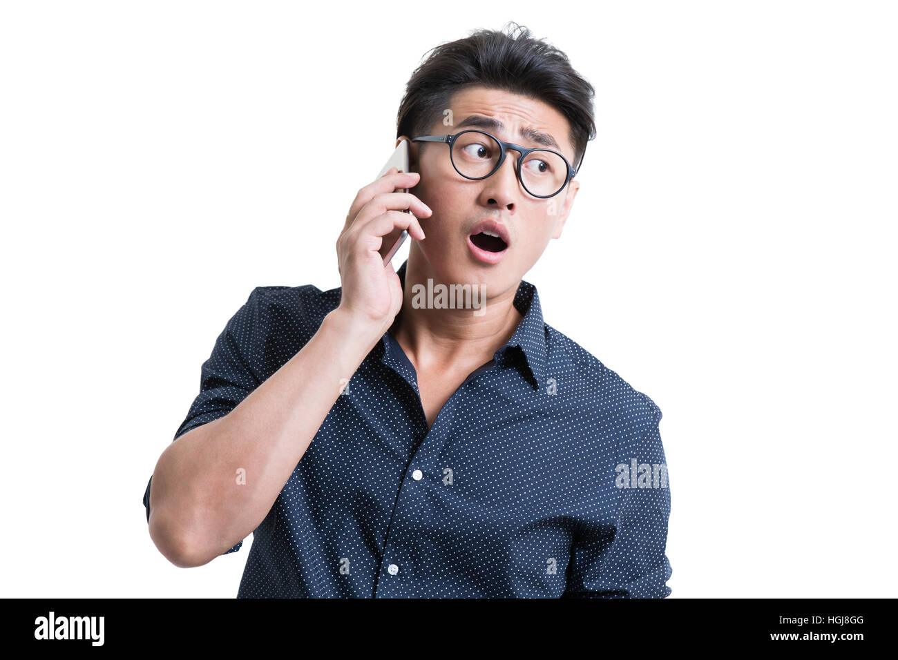 Choqué young man talking on cell phone Banque D'Images