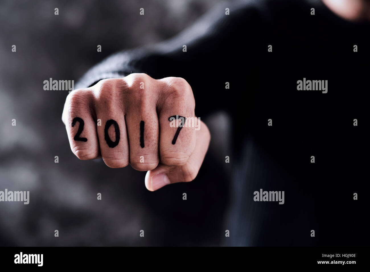 Gros plan de l'poing d'un jeune homme avec le numéro 2017, comme la nouvelle année, écrit dans ses doigts Banque D'Images