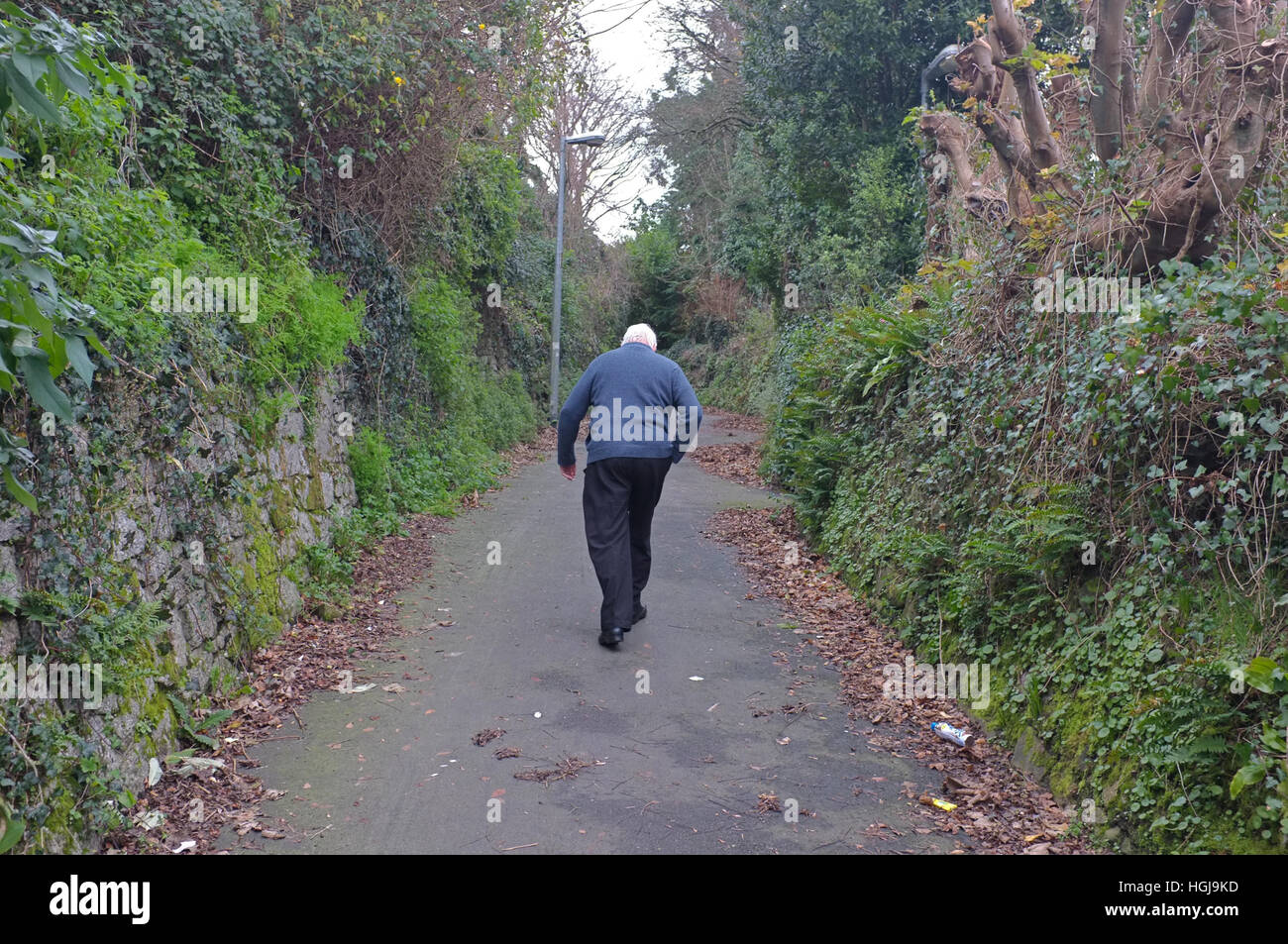 Un vieil homme marche le long d'un chemin à Cornwall, UK Banque D'Images
