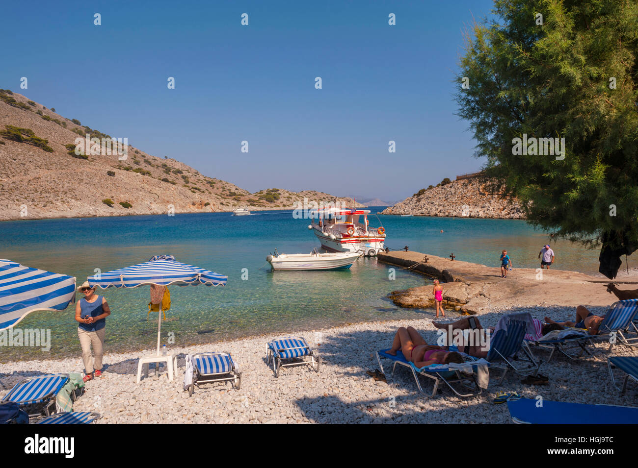 Taxi Bateau amarré au ponton de la Plage Marathounda sur symi Grèce Banque D'Images