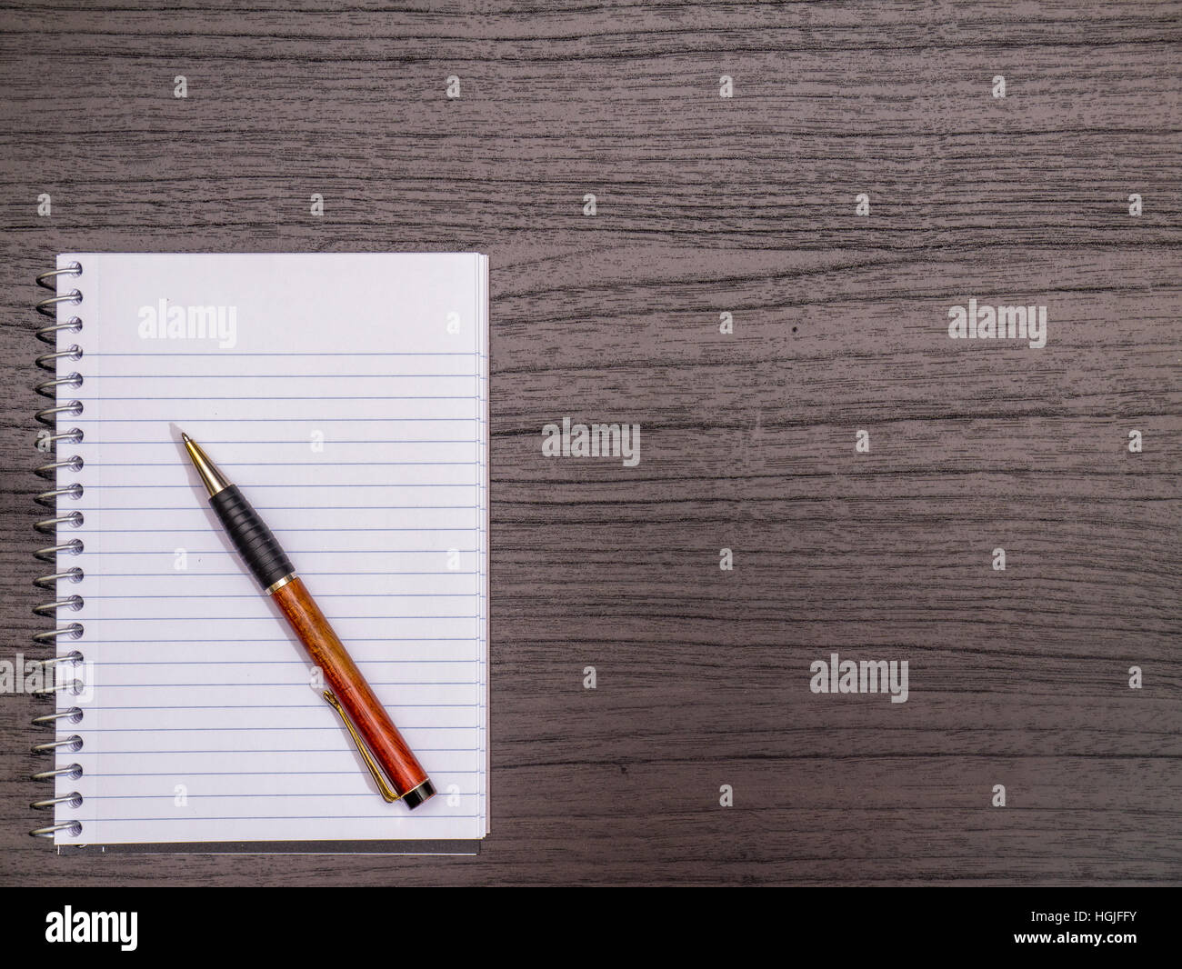 Bureau en bois foncé, crayon, carnet à spirales Banque D'Images