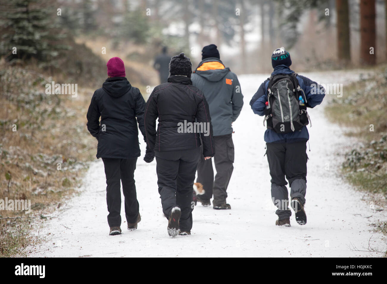 Les promeneurs appréciant un peu de neige comme ils marchent autour de la société Alwen réservoir dans le comté de Conwy, Pays de Galles, Royaume-Uni Banque D'Images