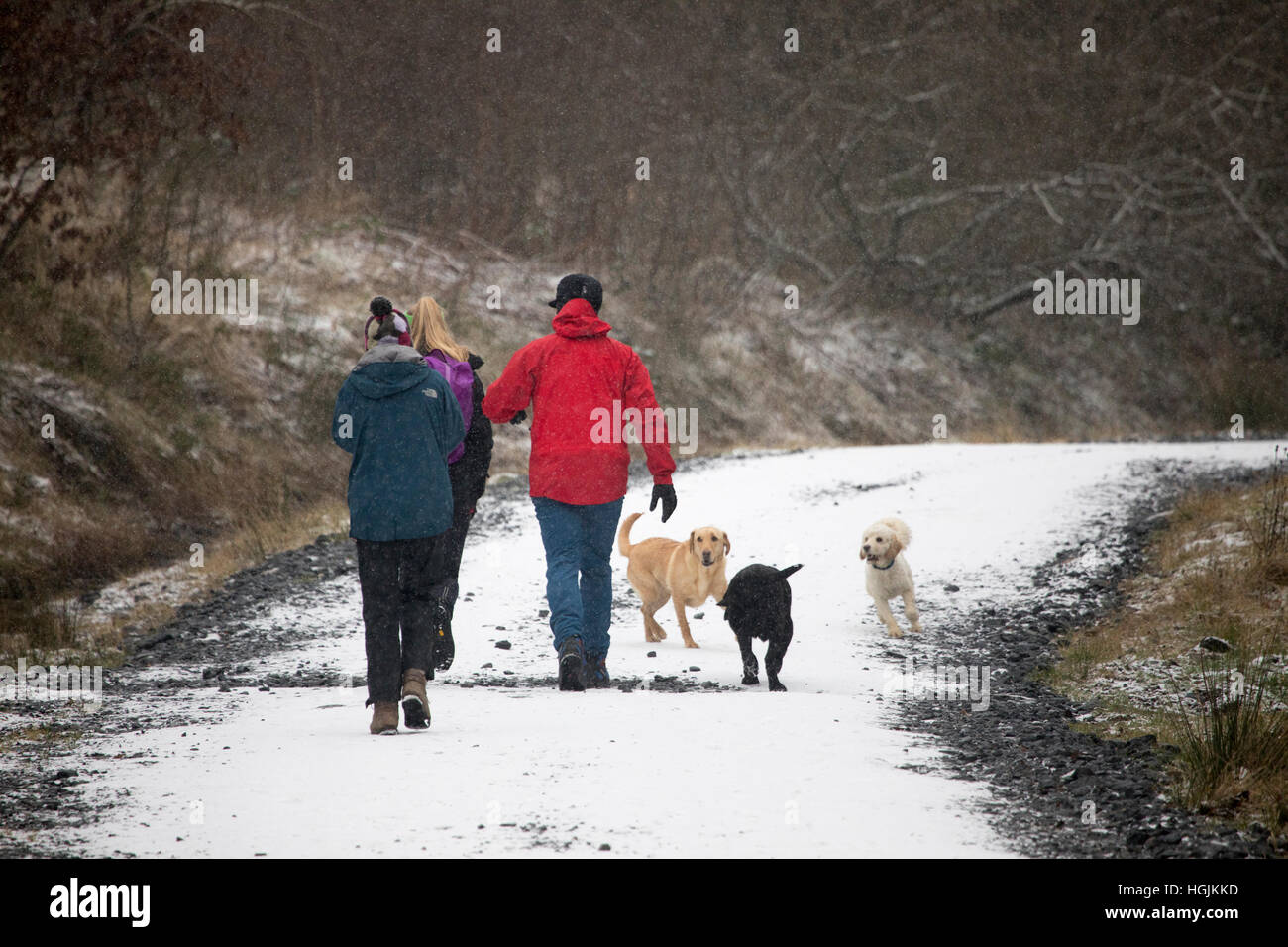 Les promeneurs appréciant un peu de neige comme ils marchent autour de la société Alwen réservoir dans le comté de Conwy, Pays de Galles, Royaume-Uni Banque D'Images
