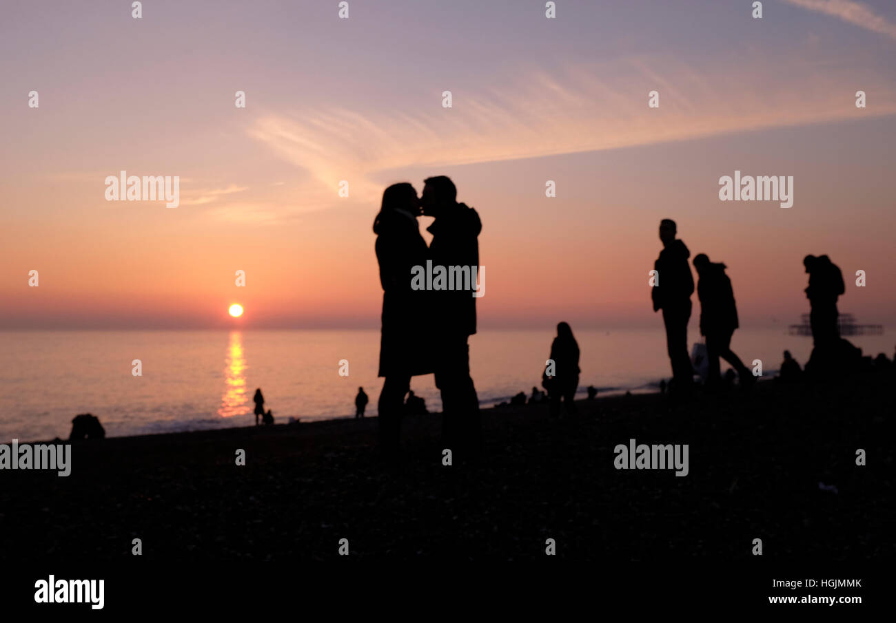 Brighton, Sussex, UK. 22 janvier, 2017. Un couple profitez d'un moment romantique sur la plage de Brighton à mesure que le soleil se couche derrière eux au crépuscule, après une froide mais belle journée sur la côte sud Crédit : Simon Dack/Alamy Live News Banque D'Images