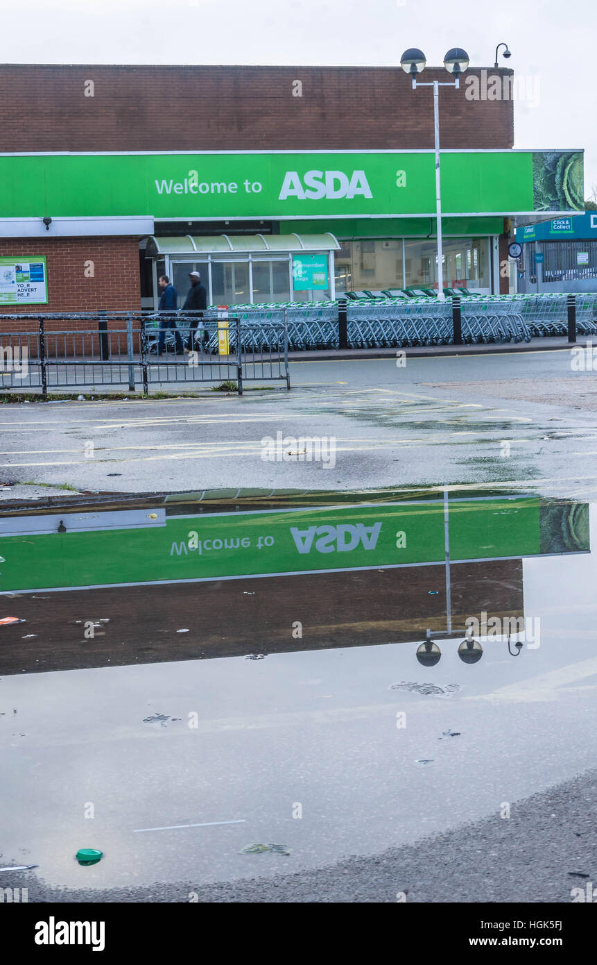 Le magasin Asda locales reflète dans une flaque d'eau. Banque D'Images