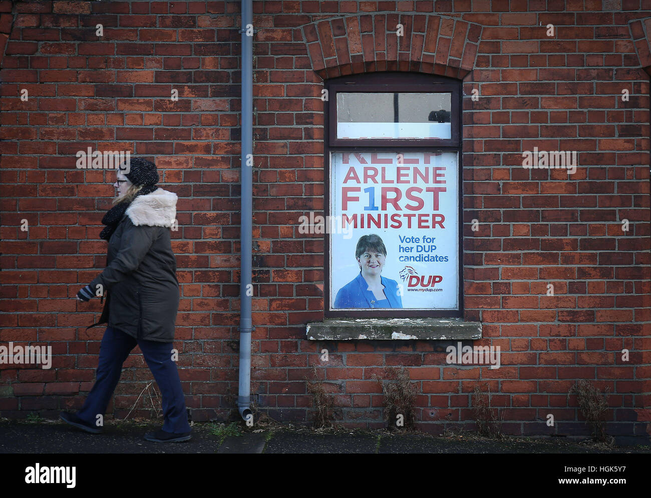 Une femme passe devant une affiche à la DUP siège à Belfast que le gouvernement britannique a lancé un appel aux dirigeants politiques de l'Irlande du Nord à l'étape de s'en sortir de la crise politique actuelle. Banque D'Images