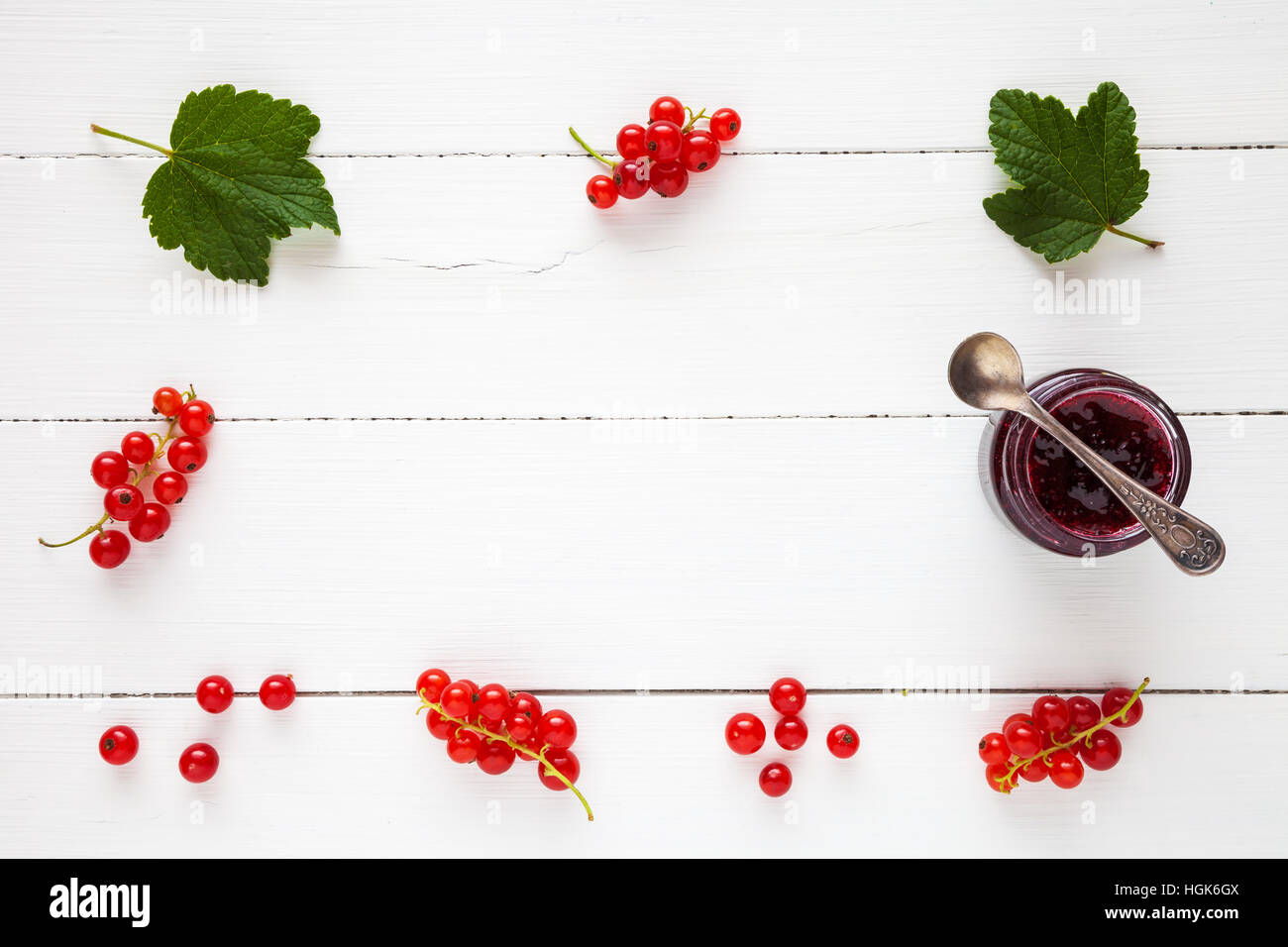 Confiture de groseille rouge et de baies de groseilles fraîches comme frontière avec copie espace sur le tableau blanc. Mise à plat, vue du dessus. Banque D'Images