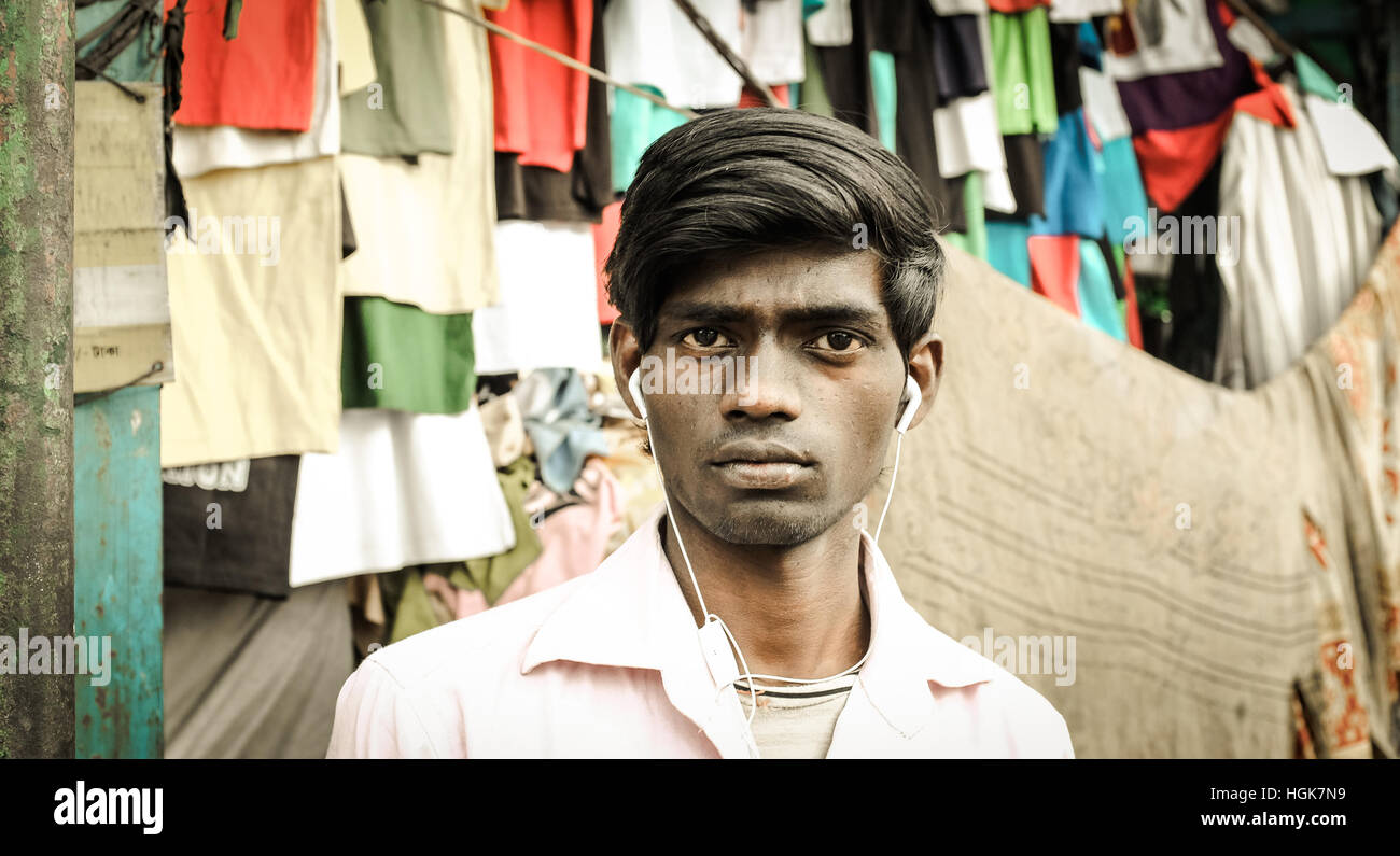 Jeune homme moderne indien à Calcutta marché avec casque blanc. Banque D'Images